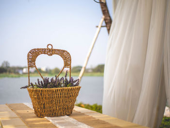 Close-up of wicker basket on table against sea