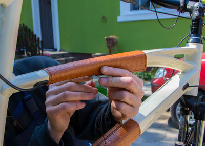 Close-up midsection of hands sewing bicycle seat