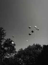 Low angle view of balloons flying against sky