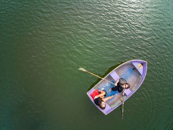 High angle view of friends rowing boat on lake