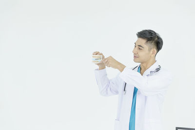 Man looking away while standing against white background