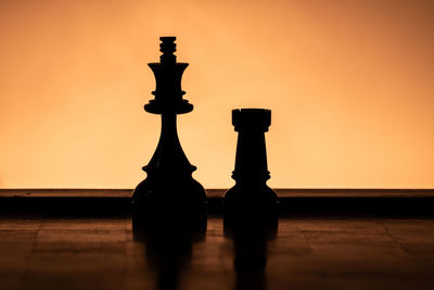 Close-up of chess pieces on table at sunset