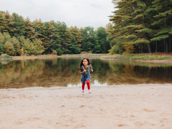 Full length portrait of man standing on riverbank