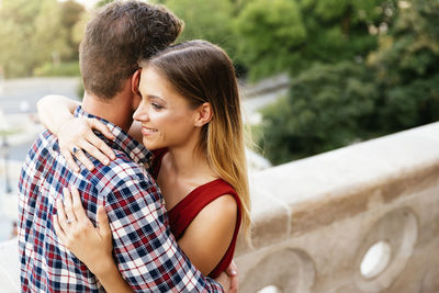 Smiling couple embracing while standing outdoors