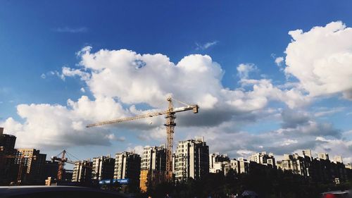 Panoramic view of construction site by buildings against sky