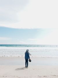 Full length of woman on beach against sky