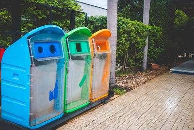 Colorful garbage cans on footpath in city