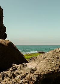 Rocks on beach against clear sky