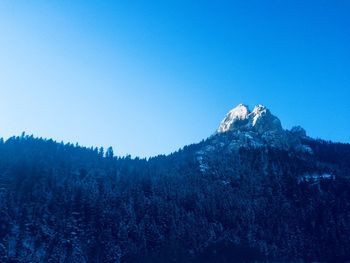 Low angle view of mountain against clear blue sky