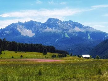 Scenic view of field and mountains against sky