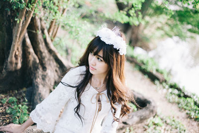 Tilt shot of young woman looking away in forest