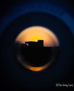 Close-up of camera against sky during sunset