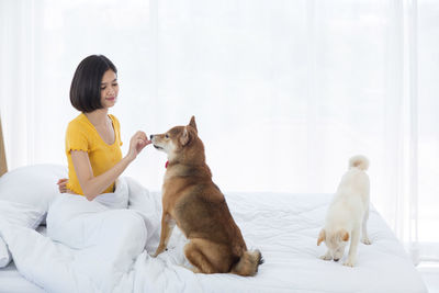 Young man sitting with cat on bed