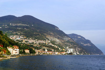 Scenic view of sea by buildings against sky