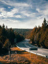 Road amidst trees against sky