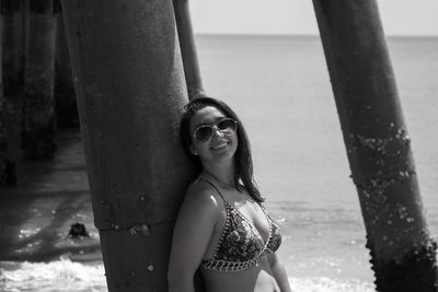 Woman standing against pier at beach