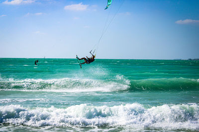 Person paragliding at beach