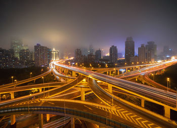 High angle view of illuminated city street and buildings at night