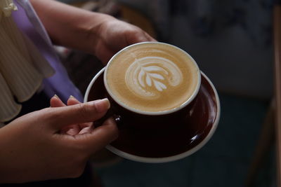 Close-up of hand holding coffee cup