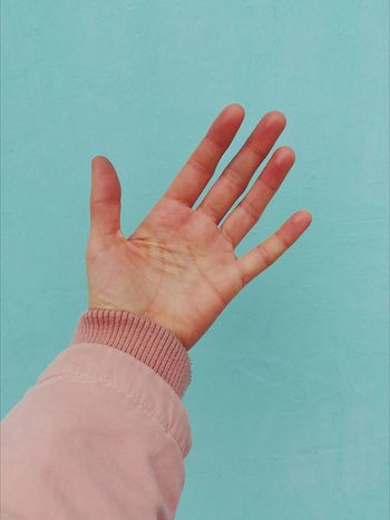 Close-up of human hand against blue background