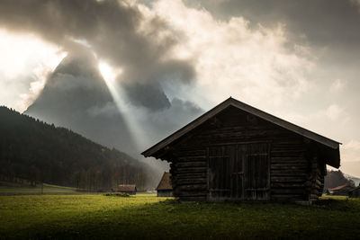 House on field against sky at garmisch-partenkirchen in the german alps