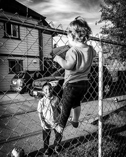 Boy playing with chainlink fence