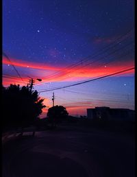 Silhouette trees against sky at night