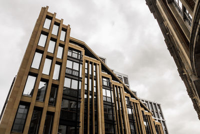 Low angle view of buildings against cloudy sky