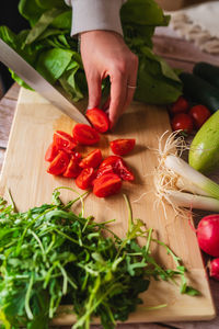 Cropped hand of person preparing food on cutting board