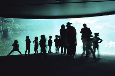 Silhouette people against sea