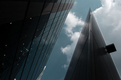 Low angle view of modern building against cloudy sky