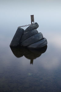 Close-up of rock on lake against sky