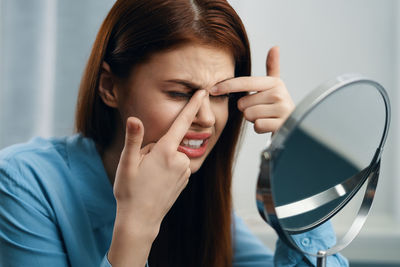 Close-up of woman squeezing pimple