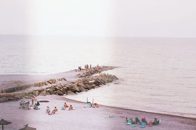 People at beach against sky