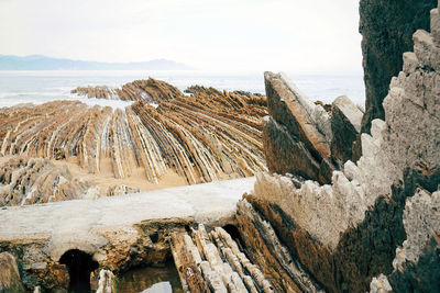 Panoramic view of rocks on beach against sky