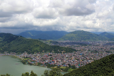 Aerial view of townscape and mountains against sky