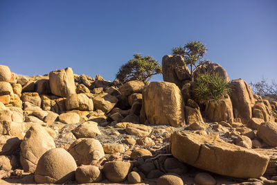 View of rocks against clear blue sky