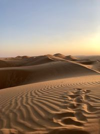 Sand dunes in desert against clear sky