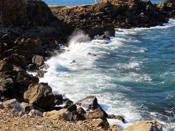 Scenic view of rocks in sea against sky