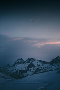 Scenic view of snowcapped mountains against sky at dusk