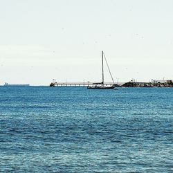 Sailboats in sea against clear sky