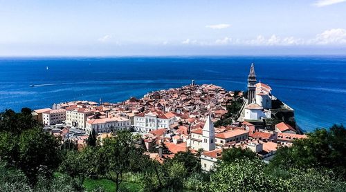 High angle view of townscape by sea against sky