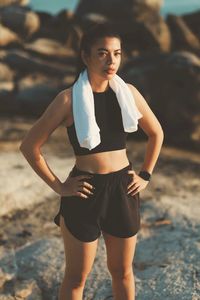 Portrait of young woman standing at beach