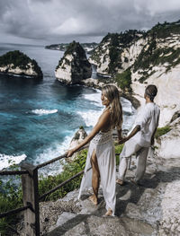 A couple at the famous diamond beach of nusa penida / bali.