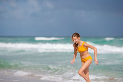 Full length of girl playing at beach