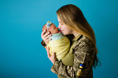 Woman with daughter against blue background