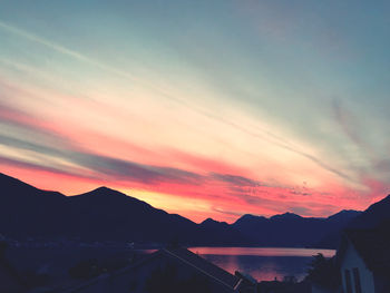 Scenic view of silhouette mountains against romantic sky at sunset