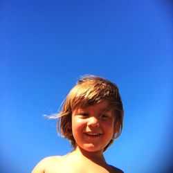 Portrait of cute smiling boy against clear blue sky