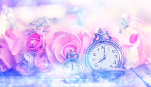 Close-up of pocket watch with flower decorations on table