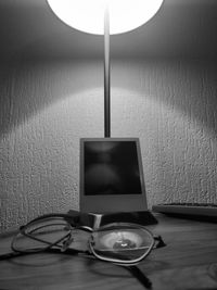 Close-up of electric lamp on table against wall